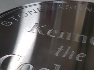 Engraved stainless steel sign with letters cut into the metal