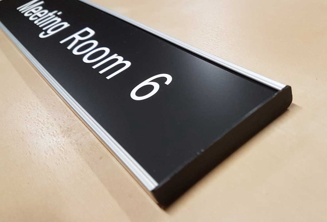 aluminium wall and door name bar with a black name plate and white lettering